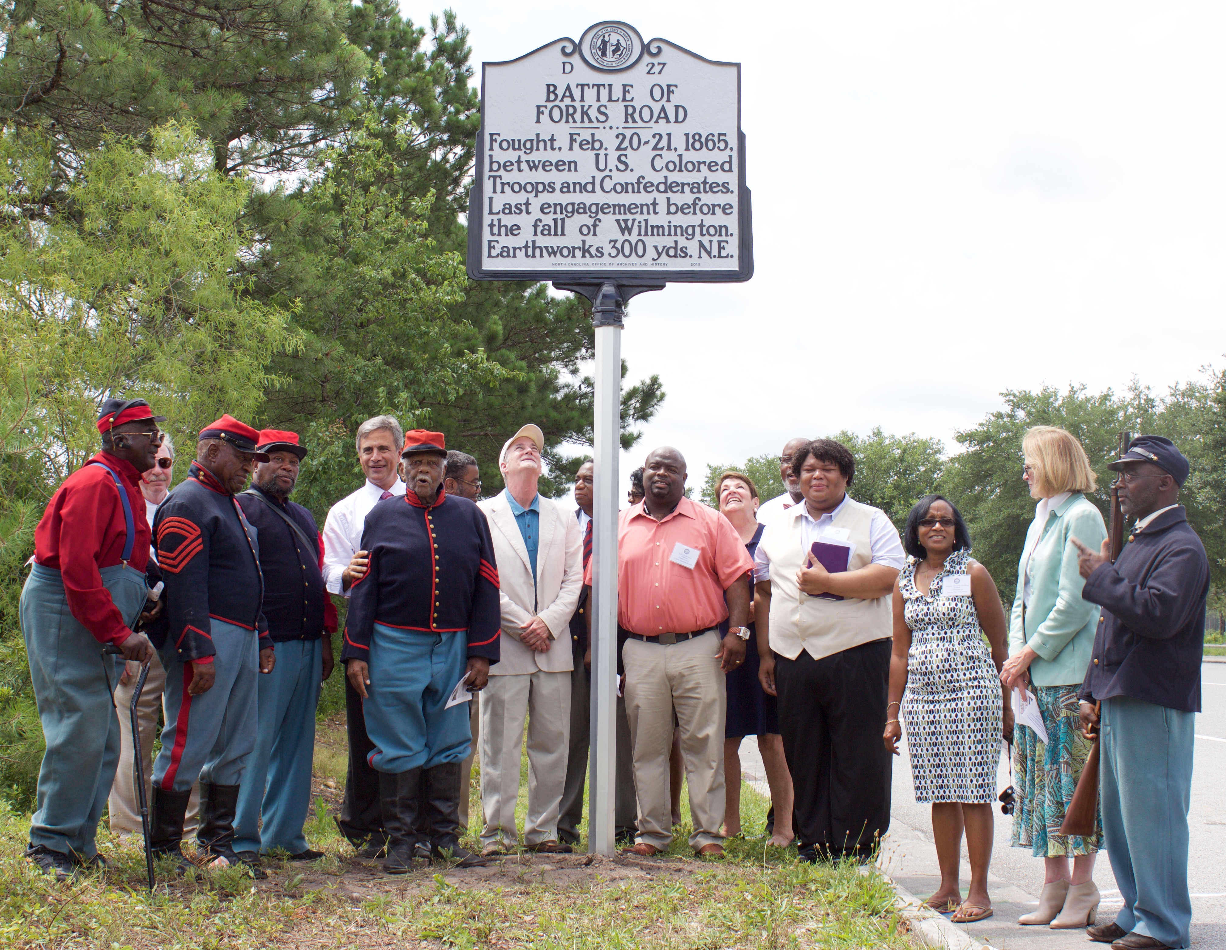 Members of the Wilmington City Council, African American History Commission, and Chairman of the New Hanover County Commissioners Jonathan Barfield Jr. help unveil the historical marker with reenactors of the Battle of Forks Road.