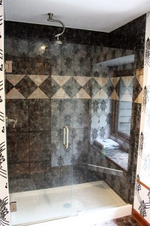 In the master bathroom, the shower is surrounded by stone and glass, giving it the feel of a Caribbean grotto, complete with views of the carefully groomed tropical landscape behind the house. (Port City Daily photo/CORY MANNION)