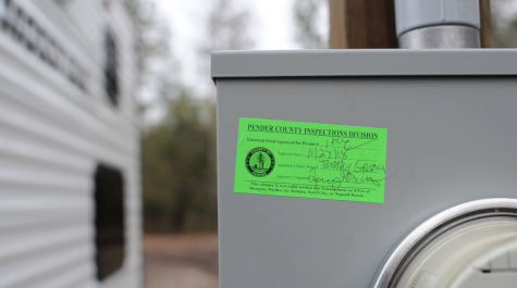 A Pender County Inspections approval notice on the temporary electric pole installed by a FEMA contractor. (Port City Daily photo/Mark Darrough)