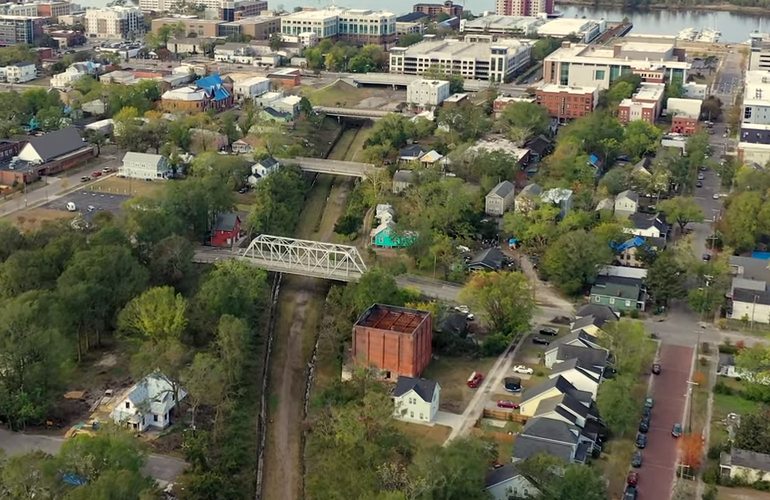 The former Independent Ice House in Wilmington's North side can be seen in the foreground here, below the iconic white 'One Tree Hill' bridge on North 6th Street. (Port City Daily photo / Courtesy Wilmington Rail Trail)