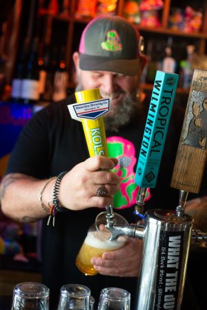 Duck and Dive bartender Aaron Carter pours a draft of Waterline's Kolsch beer. He said the brewery has made a name for itself by finding a niche in a market heavy on IPAs. (Port City Daily photo/Mark Darrough)
