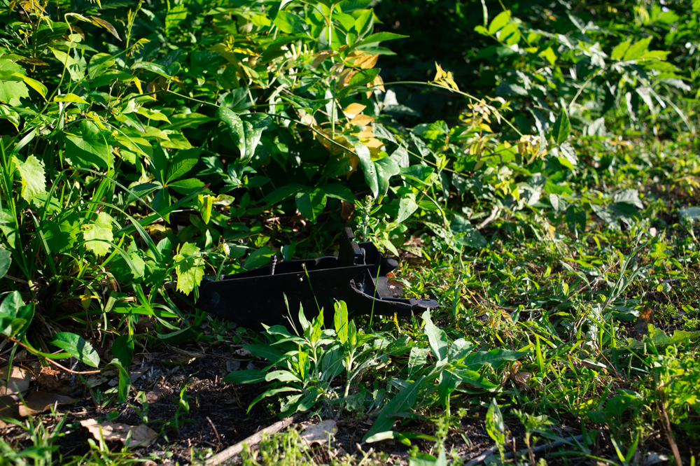 On Wednesday evening, plastic car debris could be seen along the tree line from the nearby Watemark Marina entrance road. (Port City Daily photo/Mark Darrough)