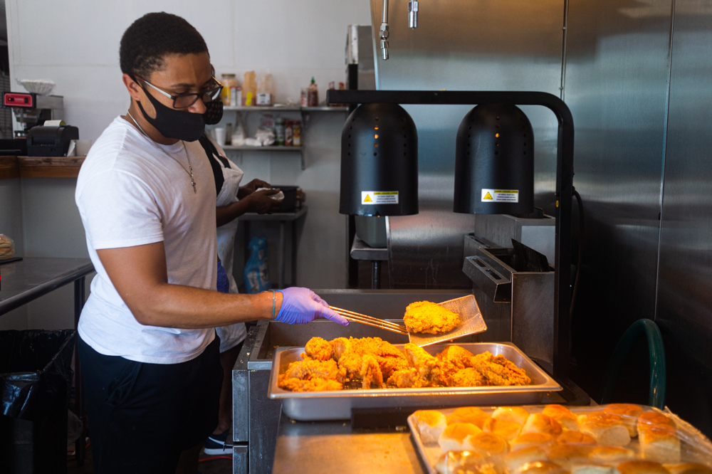 Kevin Corbett, who opened Chicken in a Box with his family this past weekend, throws a hot chicken breast on the tray late Monday afternoon. (Port City Daily photo/Mark Darrough)