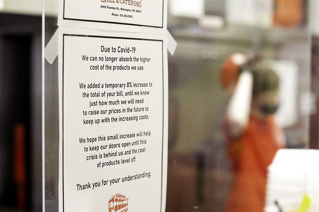 Trolly Stop has signs posted to inform customers of the temporary surcharge they've added to make up from increase costs on products from Covid-19. (Port City Daily photo/Johanna F. Still)
