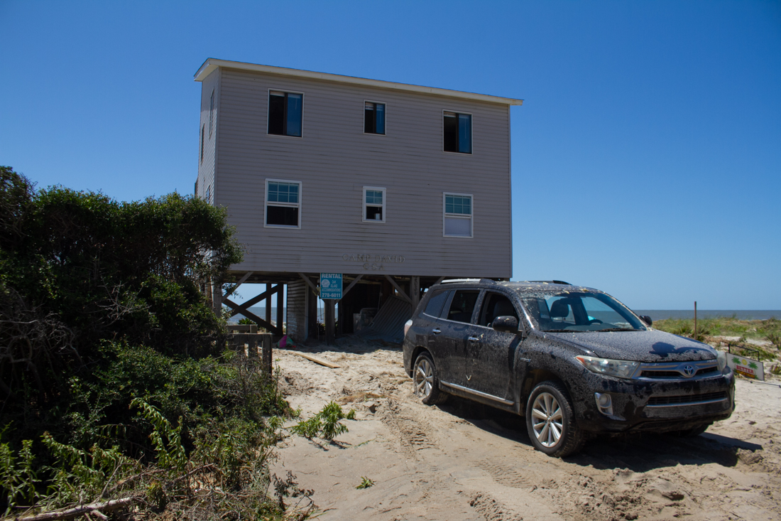 A totaled car sits in front of a rental home with all its windows left open to air out water damage caused by Hurricane Isaias' storm surge. The home's dryer was found across the street the next morning. (Port City Daily photo/Johanna F. Still)